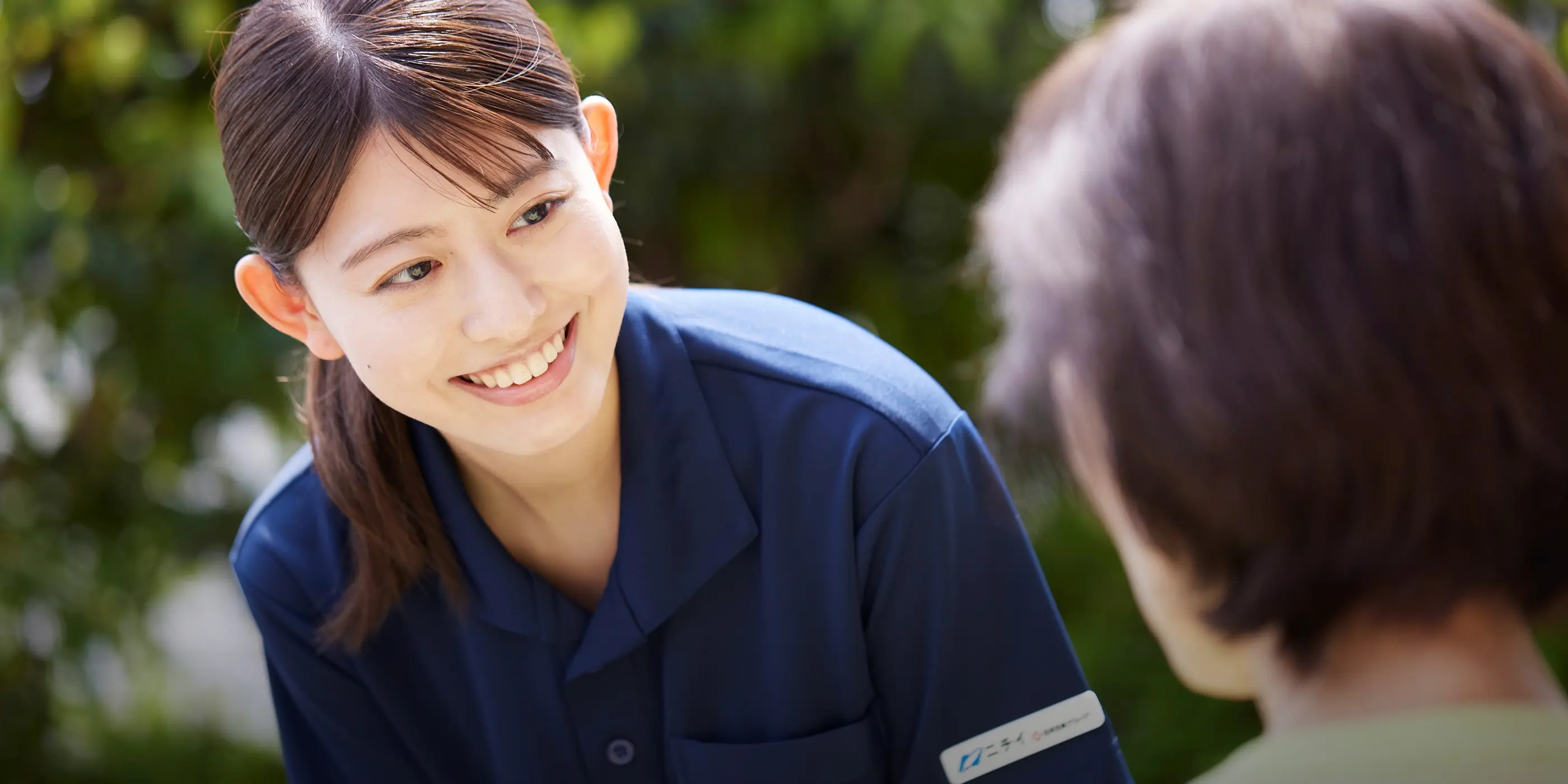 利用者と笑顔で接するエリア限定型の女性スタッフ