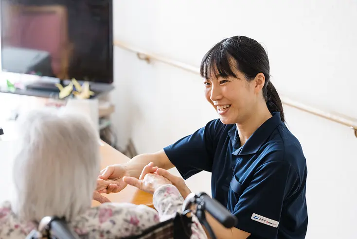 ニチイのスタッフが笑顔で利用者と接したり、会議をしたりしている様子